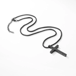 Détail du collier croix en acier noir mat avec gravure You Are Never Alone inspirante