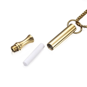 Detail of gold breathing meditation whistle necklace with removable cap and sponge core
