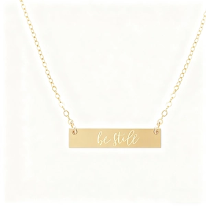 Polished gold rectangular bar necklace with 'be still' engraving on a cross chain