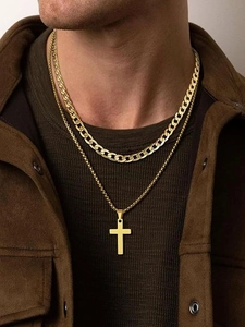 Close-up of double-layer gold Cuban chain and cross pendant on a male model