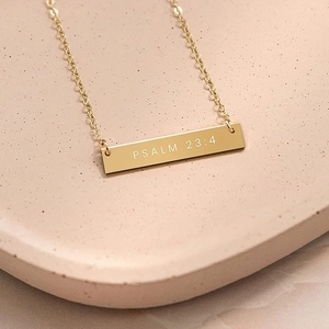 Detail view of gold bar necklace engraved with Psalm 23:4 on a refined chain