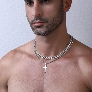 Detail view of double-layered silver stainless steel necklace with cross pendant on model