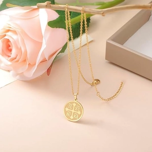 Golden Orthodox IC XC NIKA cross medallion necklace hanging on a branch with pink roses