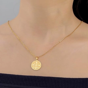 Golden IC XC NIKA Orthodox cross medallion pendant necklace worn by a female model