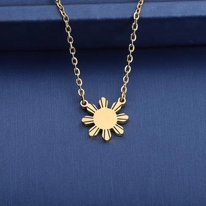 Collier avec pendentif soleil minimaliste en acier inoxydable doré sur fond bleu marine