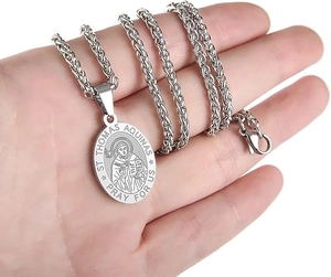 Gros plan d'un pendentif ovale Saint Thomas d'Aquin sur une chaîne en acier inoxydable
