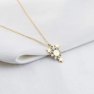 Collier en acier inoxydable doré avec pendentif soleil et étoiles sur satin blanc