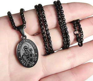 Detail of black stainless steel Saint Anthony pendant with engraved Pray For Us text