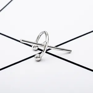 Detailed view of a silver geometric C-shaped cross ear cuff with minimalist design