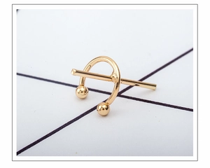 Macro view of gold geometric C-shaped cross ear cuff clip for non-pierced ears