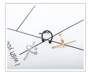 Macro shot of U-shaped cross ear cuffs in silver, gold, and black polished steel