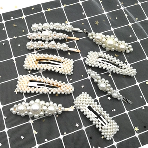 Detailed view of 9-piece pearl hair clip set with geometric shapes on textured background