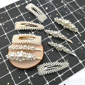 Detail of 8-piece pearl hair clip set featuring gold metal bases and white faux pearls