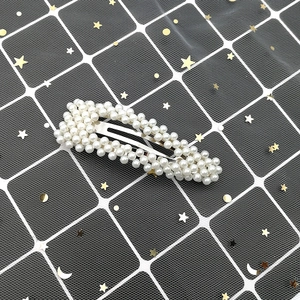 Close-up of a Korean style pearl hair clip featuring white imitation pearls on a metal base