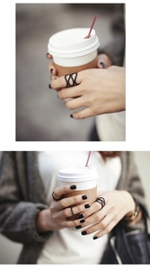 Close-up of minimalist matte black rings set featuring wave designs and sleek bands