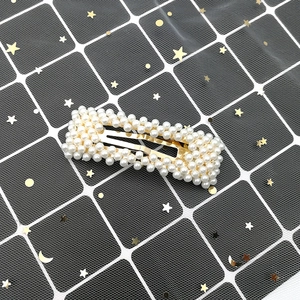 Close-up of rectangular hair clip with white pearls and gold alloy base for women
