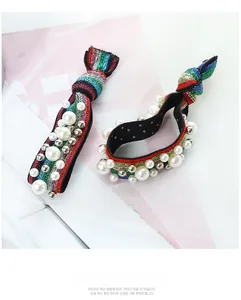 Detail of rainbow striped sequin hair tie decorated with white pearls and silver beads