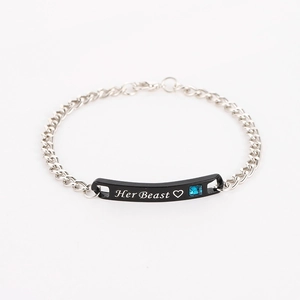 Detail of Her Beast engraved black bar bracelet with blue gemstone and silver chain