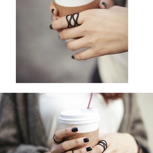 Minimalist matte black wavy rings set in a lifestyle coffee cup holding scene