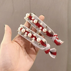 Close-up of red and silver elastic hair ties with pearls and silver beads detail