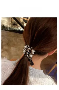 Leopard print hair scrunchie with white pearls and lace trim shown on a ponytail