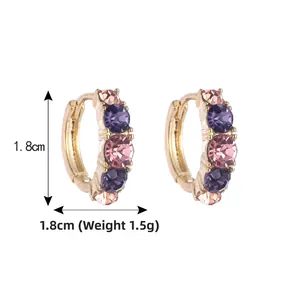 Détail des boucles d'oreilles dorées de 1,8cm avec cristaux de zircone violets et roses