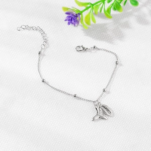 Bohemian silver bracelet set with detailed shell and whale tail charms on a bead chain