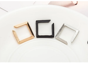 Close-up of minimalist square ear cuffs in gold, silver, and matte black finish