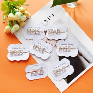 Set di 7 fermagli dorati con strass e scritte GIRLS e STAR su sfondo arancione acceso