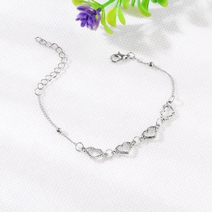 Silver beach style bracelet set with hollow heart pendants and adjustable lobster clasp