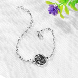 Silver chain bracelet detail with black crystal pendant, lobster clasp and extender