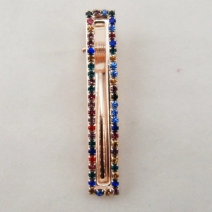 Dettaglio del fermaglio rettangolare con strass colorati su metallo oro rosa lucido