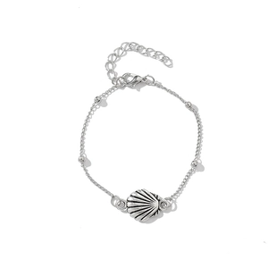 Close-up of a silver-tone shell pendant bracelet with fine chain and metallic beads