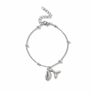Detail of silver beach bracelet set featuring shell charms and whale tail pendants