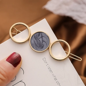 Barrette dorée moderne avec cercles en marbre sur un fond élégant et chaleureux