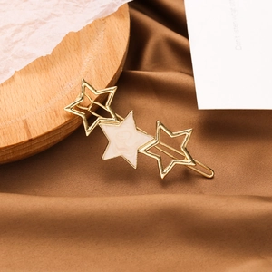 Détail de la pince à cheveux étoile avec résine marbre blanc et étoiles dorées