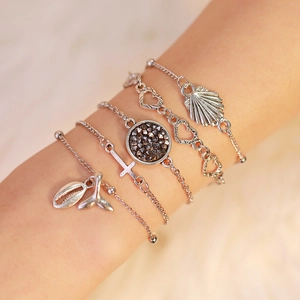 Five-piece silver beach bracelet set featuring shell, fish tail, and heart charms