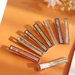 Set di fermagli per capelli rettangolari con strass colorati su sfondo arancione