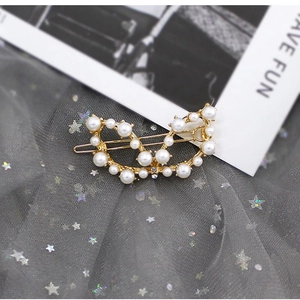 Vista macro di fermaglio per capelli in oro e perle su sfondo di tulle con stelle glitter
