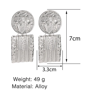 Detailed view of silver alloy vintage earrings with embossed disc and textured metal plates