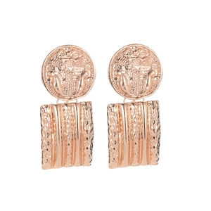 Detail of rose gold earrings featuring vintage coin embossment and hammered metal textures