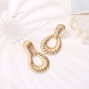 Vintage golden croissant teardrop earrings with textured alloy finish on white background