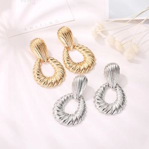 Textured gold and silver teardrop shell ripple hoop earrings set in minimalist design