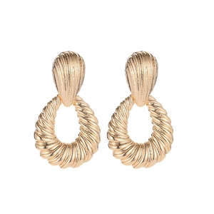Macro detail of golden drop earrings featuring vintage textured shell ripple design
