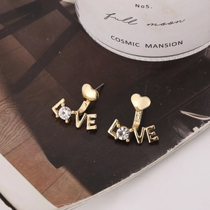 Detaillierte Nahaufnahme der vergoldeten LOVE-Ohrstecker mit Zirkon und Herz-Design-Elementen
