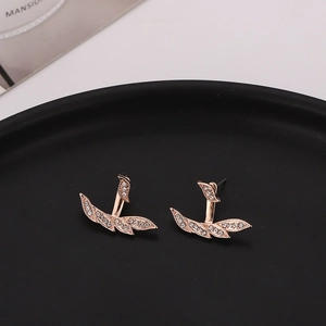 Rose gold leaf stud earrings with white cubic zirconia on a minimalist black tray