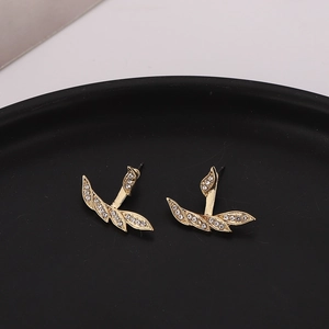 Elegant gold-tone irregular leaf earrings with sparkling white rhinestones on black tray