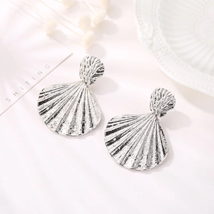 Artistic silver shell earrings with natural radiating textures on a clean white background