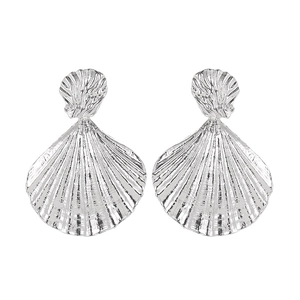 Macro shot of silver-colored shell-shaped earrings with fine vertical textures and shiny finish
