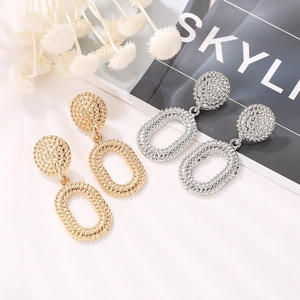 Vintage oversized metallic oval drop earrings set in textured gold and silver finishes